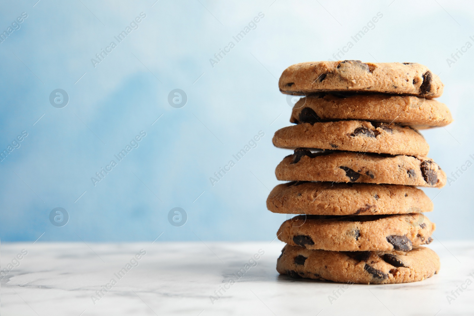 Photo of Stack of tasty chocolate chip cookies on table. Space for text