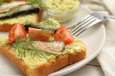 Photo of Delicious sandwiches with sprats, tomatoes, dill and avocado puree served on white table, closeup