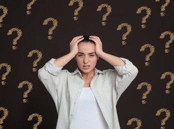 Image of Amnesia. Confused young woman and question marks on brown background