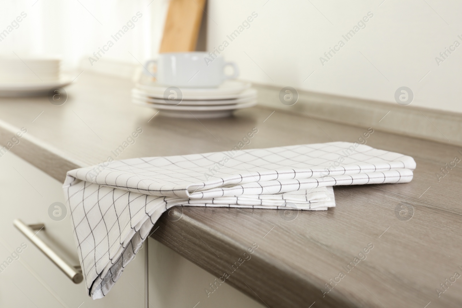 Photo of Checkered cotton towel on wooden table in kitchen