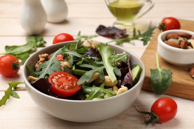 Photo of Tasty fresh vegetarian salad on light wooden table, closeup