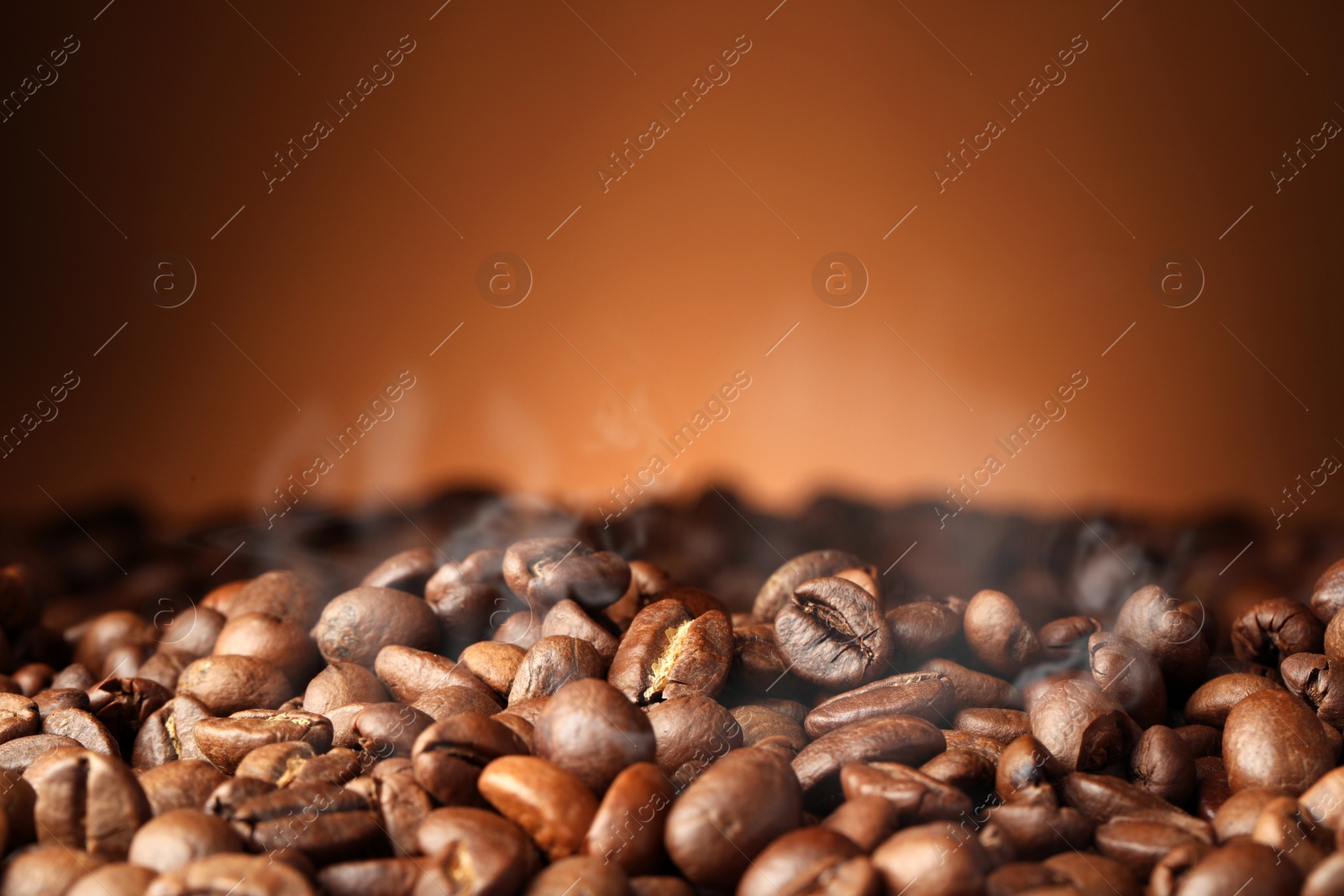 Image of Heap of aromatic roasted coffee beans on brown background, closeup