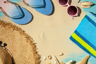 Photo of Flat lay composition with beach objects, sand and space for text on wooden background