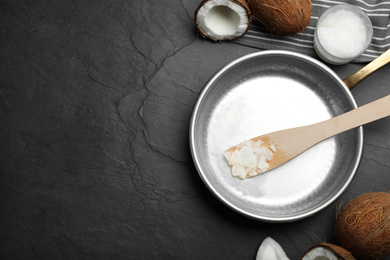 Photo of Flat lay composition with coconut oil and frying pan on black table, space for text. Healthy cooking