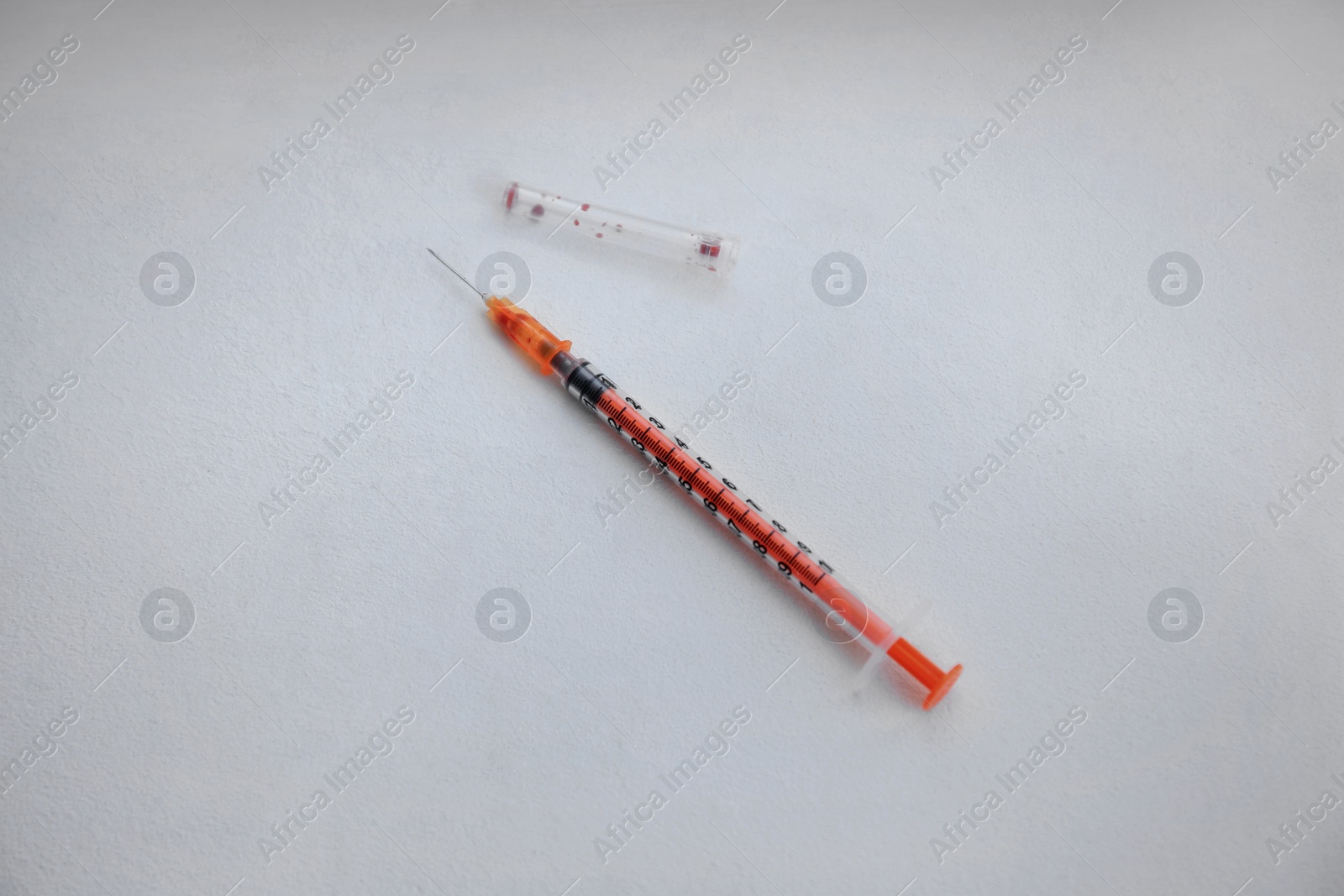 Photo of Disposable syringe with needle on white background, above view