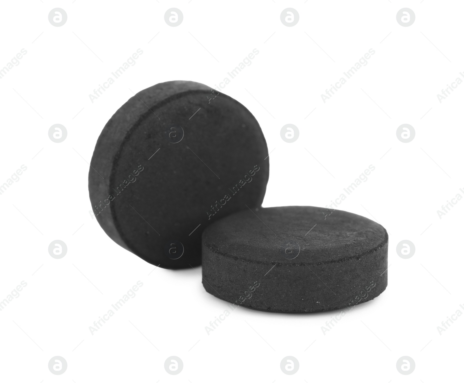 Photo of Activated charcoal pills on white background. Potent sorbent