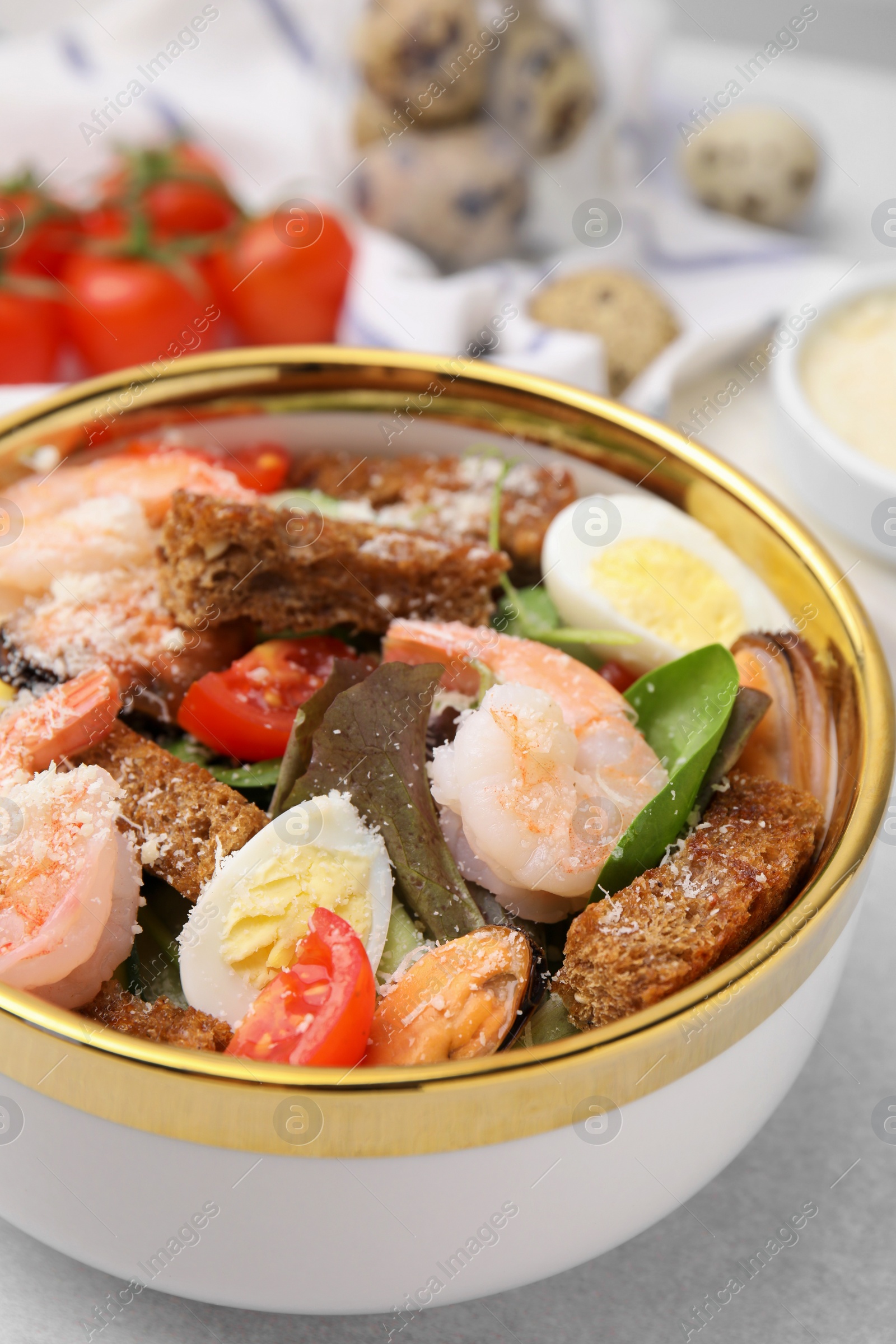 Photo of Delicious salad with croutons, tomatoes and shrimp served on white table, closeup