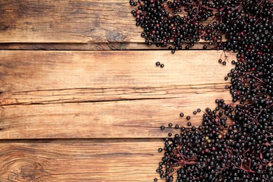 Elderberries (Sambucus) on wooden table, flat lay. Space for text