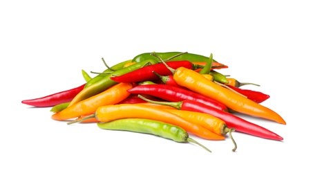 Photo of Pile of different hot chili peppers on white background