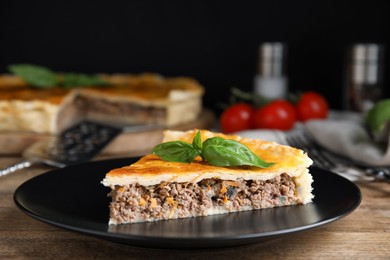 Piece of delicious pie with minced meat on wooden table