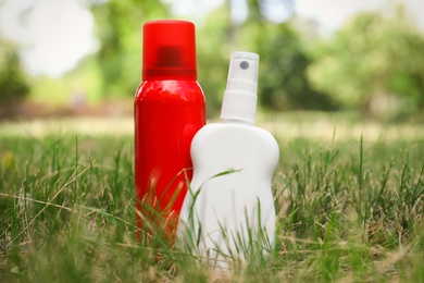 Bottles of insect repellent on green grass