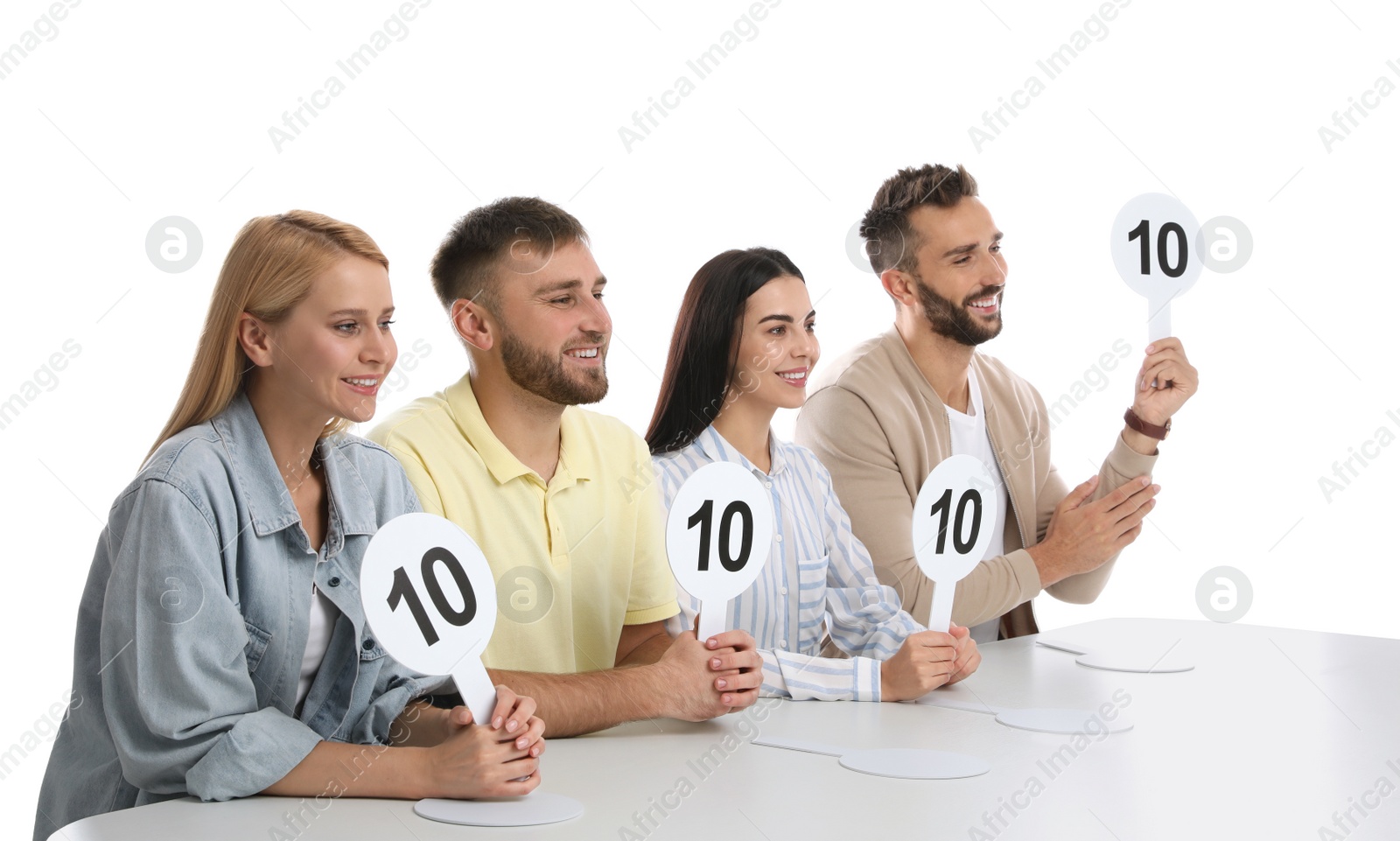 Photo of Panel of judges holding signs with highest score at table on white background