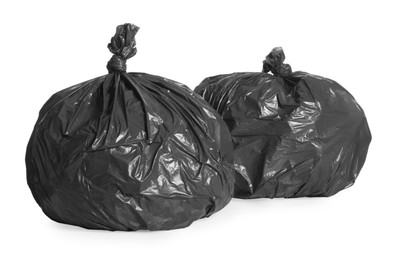 Black trash bags full of garbage on white background