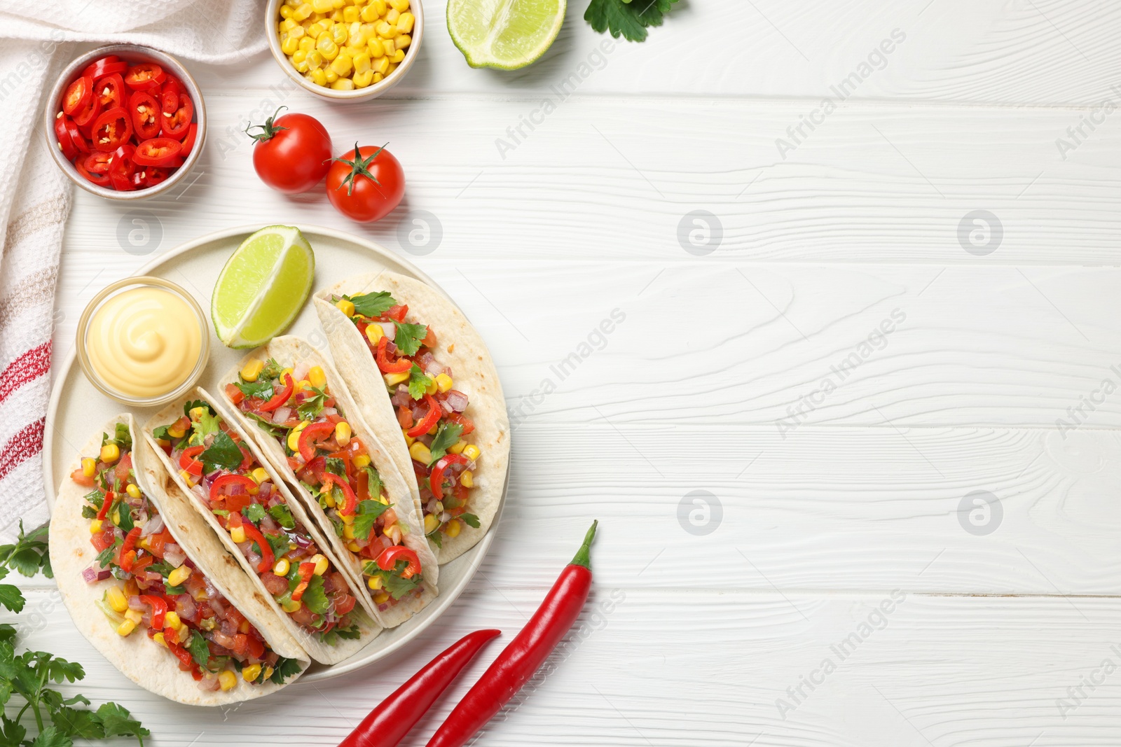 Photo of Tasty tacos with vegetables on white wooden table, flat lay. Space for text