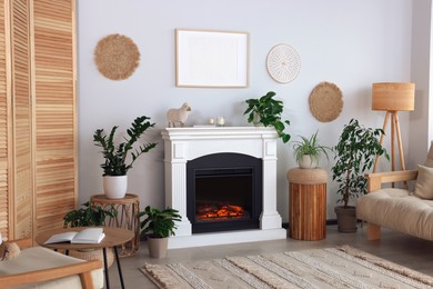 Beautiful living room interior with fireplace, green houseplants and comfortable sofa