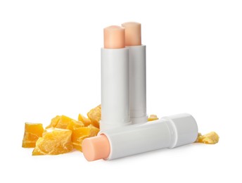 Photo of Hygienic lipsticks and natural beeswax on white background