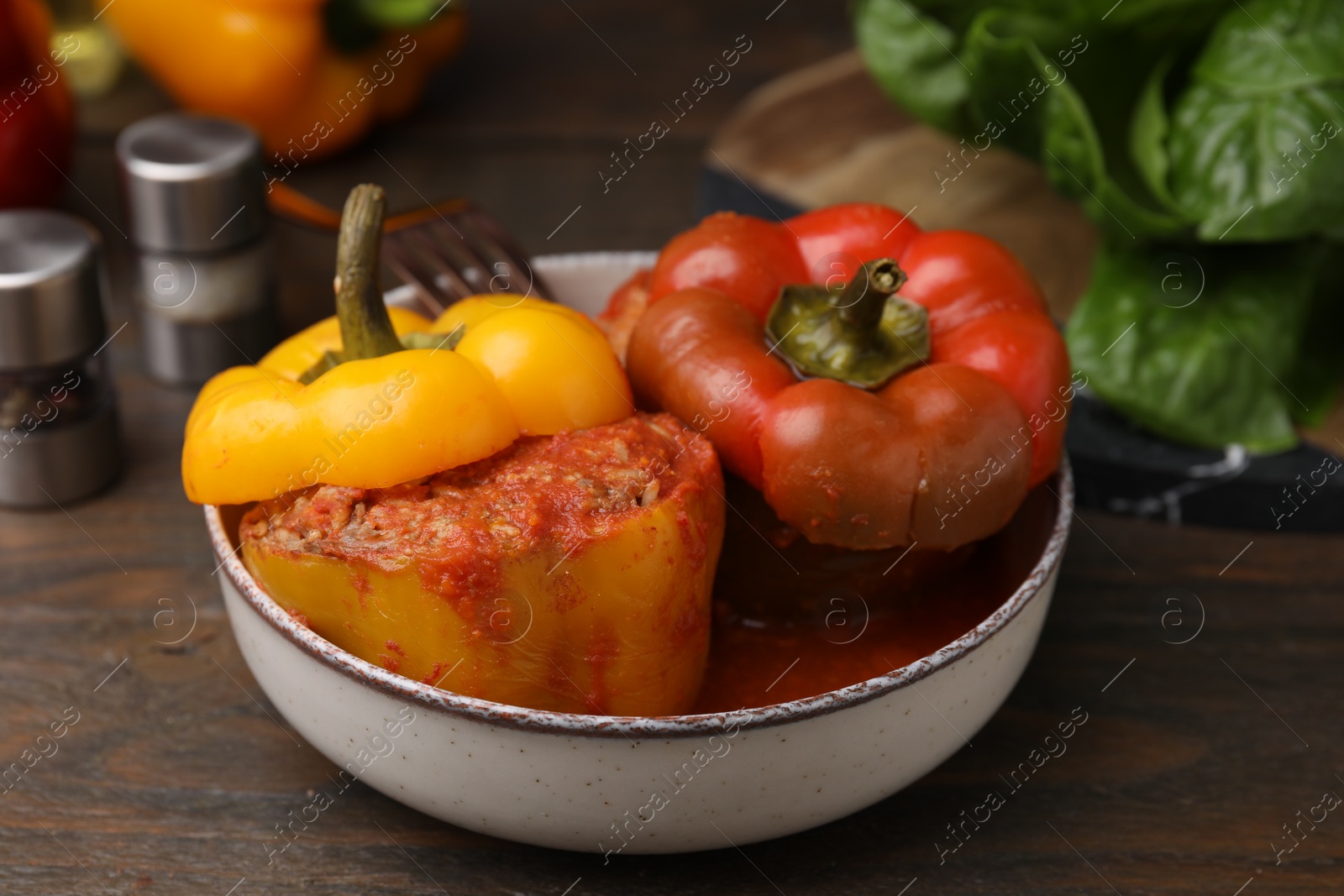 Photo of Delicious stuffed bell peppers served on wooden table