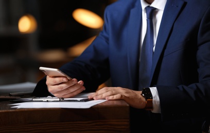 Photo of Young businessman working in office alone at night, closeup