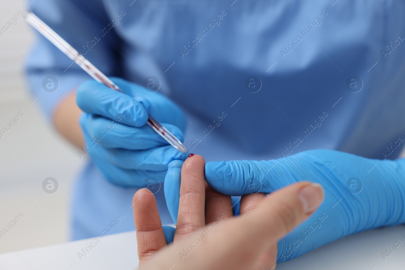 Photo of Laboratory testing. Doctor taking blood sample from patient at white table in hospital, closeup