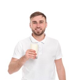 Young man with glass of tasty milk on white background