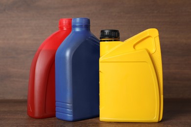 Photo of Motor oil in different canisters on wooden background