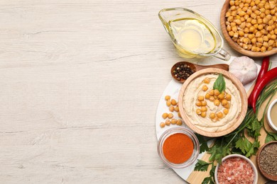 Photo of Delicious hummus with chickpeas and different ingredients on white wooden table, flat lay. Space for text