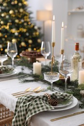 Photo of Christmas table setting with festive decor and dishware in room