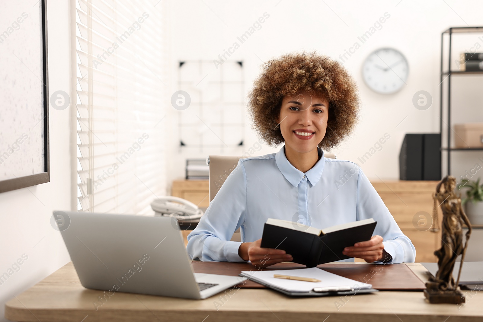 Photo of Happy notary with notebook at workplace in office