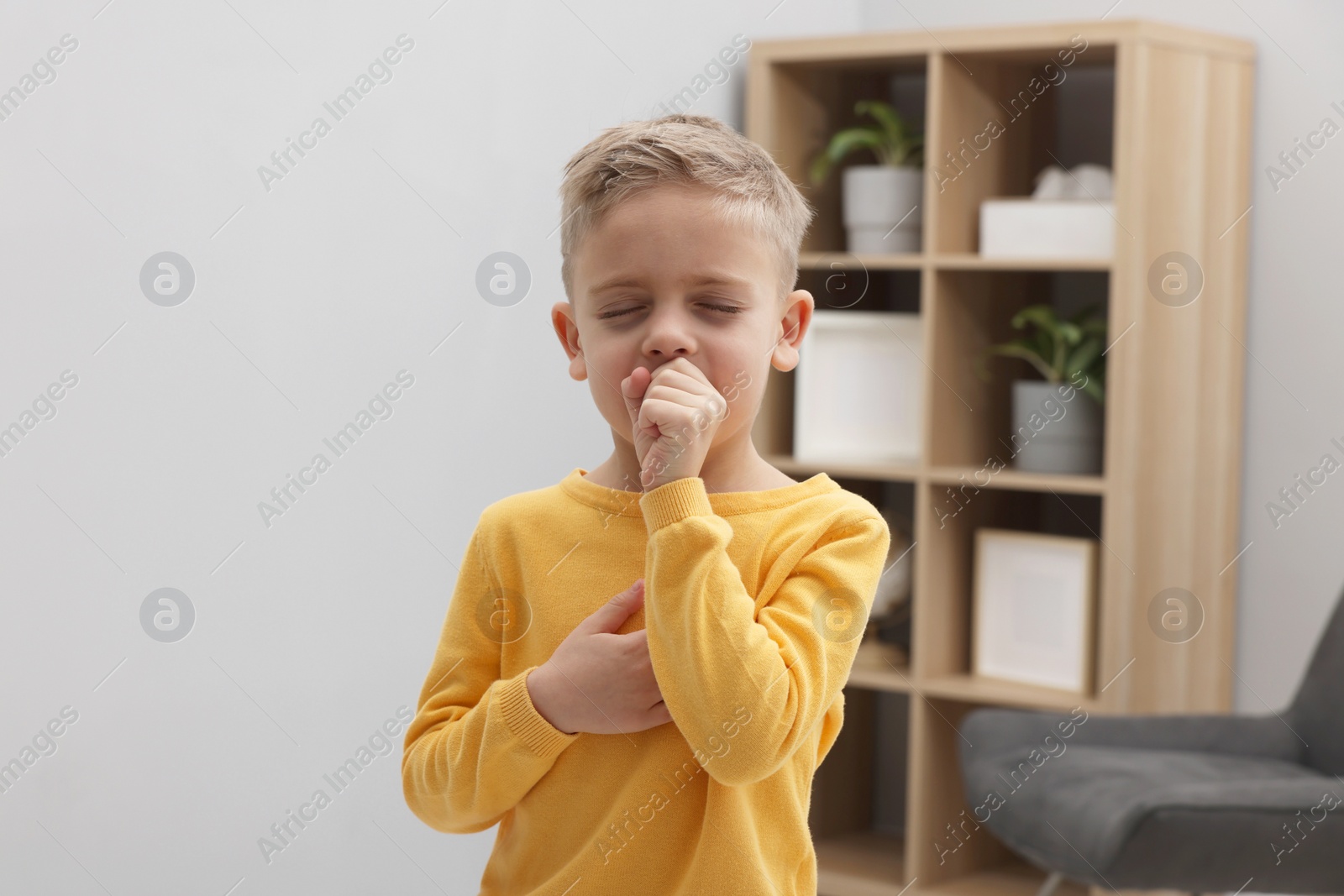 Photo of Sick boy coughing at home. Cold symptoms