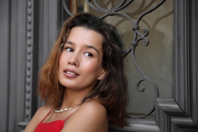 Portrait of beautiful young woman near vintage door outdoors