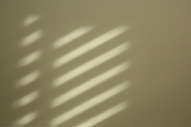 Light and shadow from window on beige wall indoors