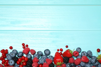 Photo of Different fresh berries on light blue table, flat lay. Space for text