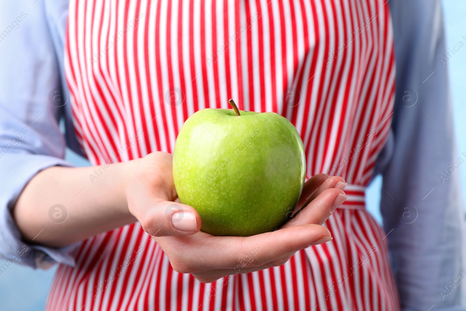 Photo of Woman holding ripe green apple, closeup view