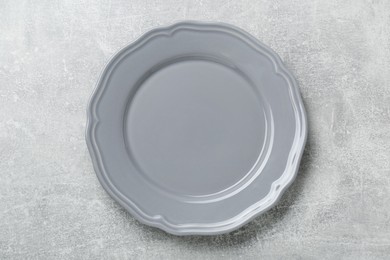 Photo of Empty ceramic plate on light grey table, top view