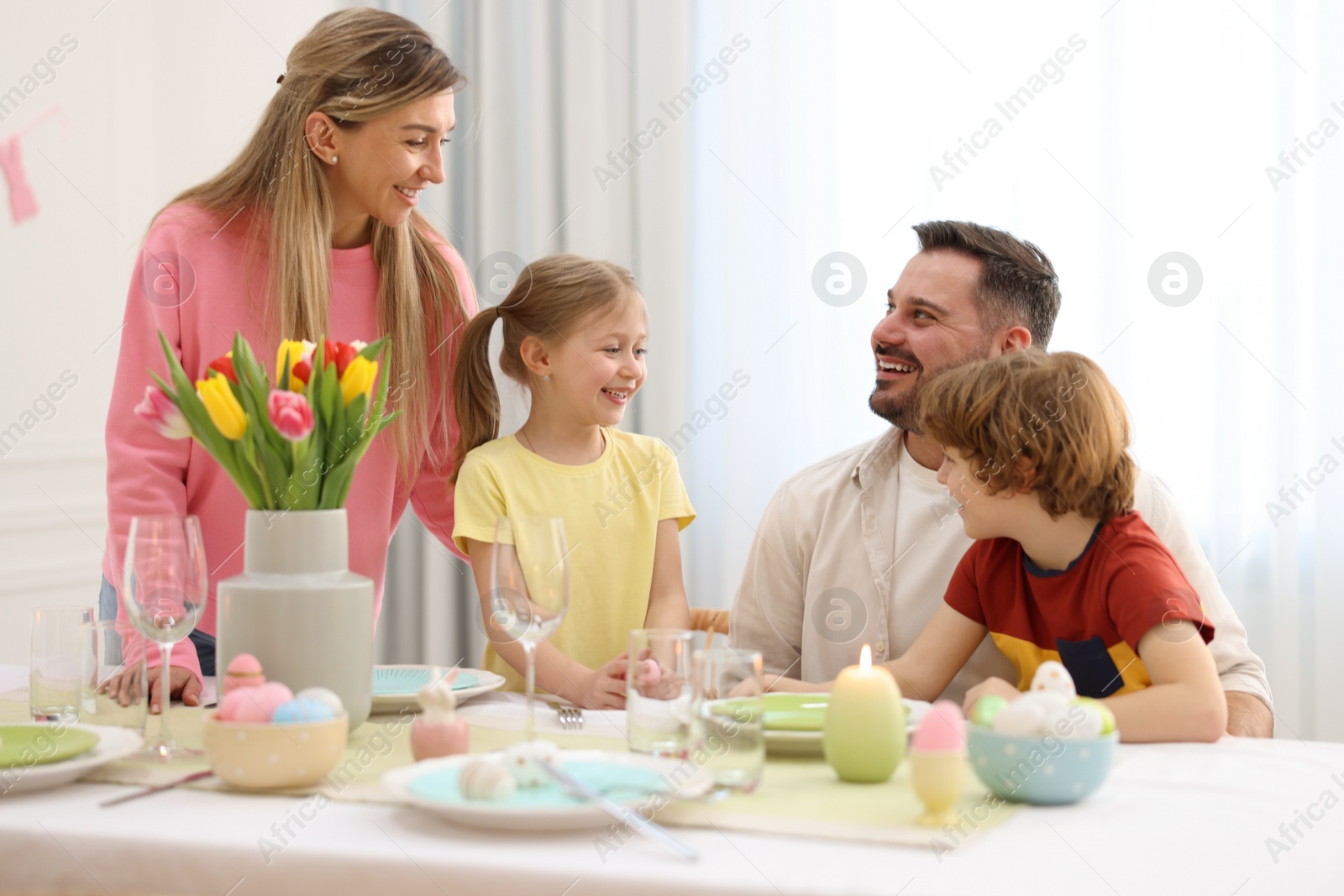 Photo of Happy family celebrating Easter at served table in room