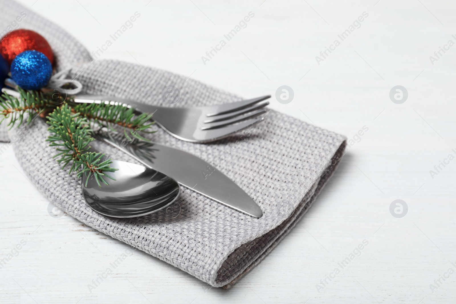 Photo of Cutlery, napkin and Christmas decor on wooden table, closeup. Festive table setting