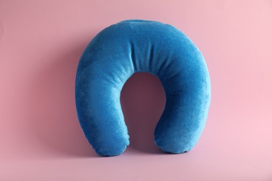 Photo of Light blue travel pillow on pink background