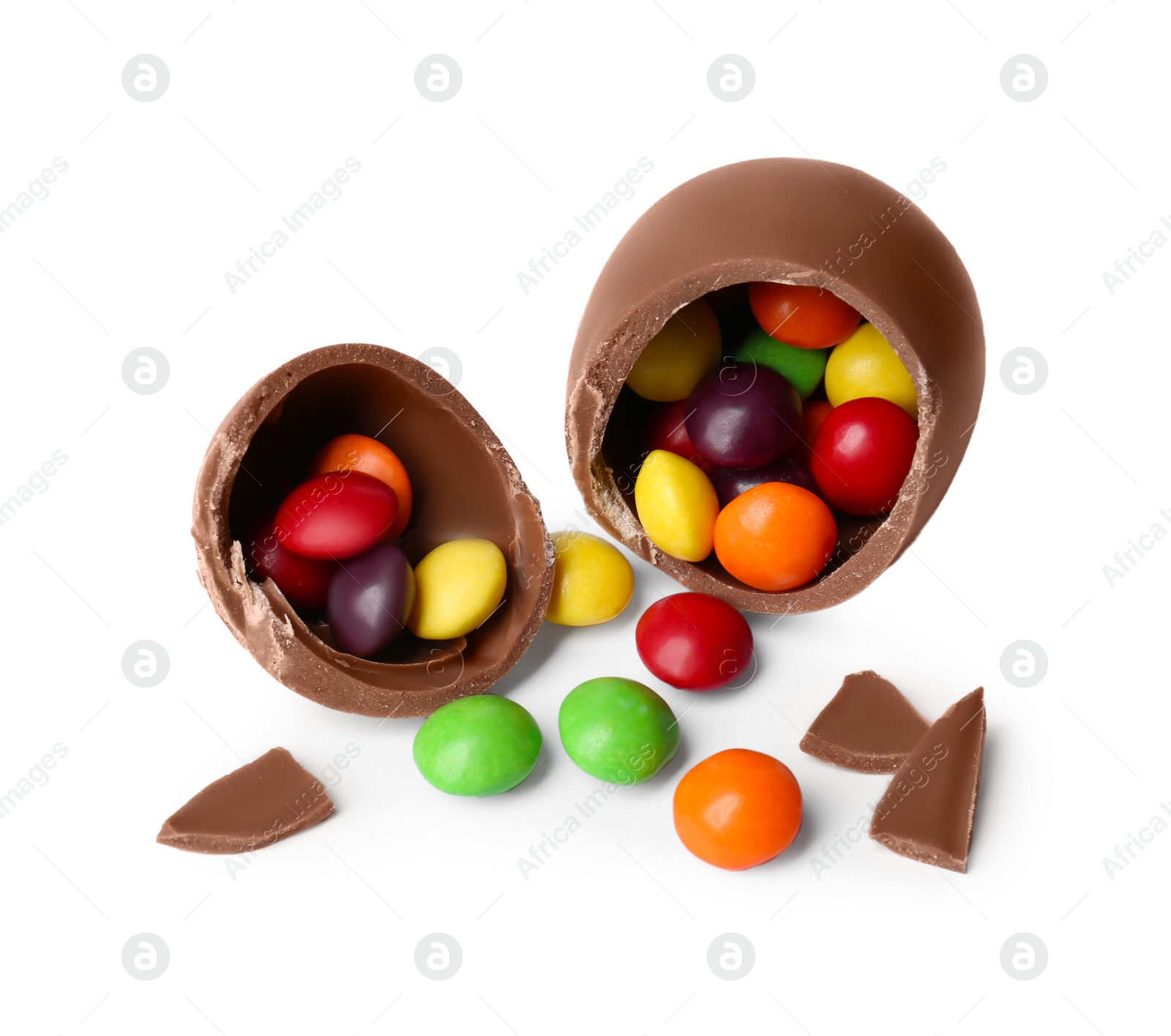 Photo of Tasty broken chocolate egg with colorful candies isolated on white