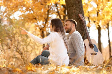 Young couple with guitar in autumn park