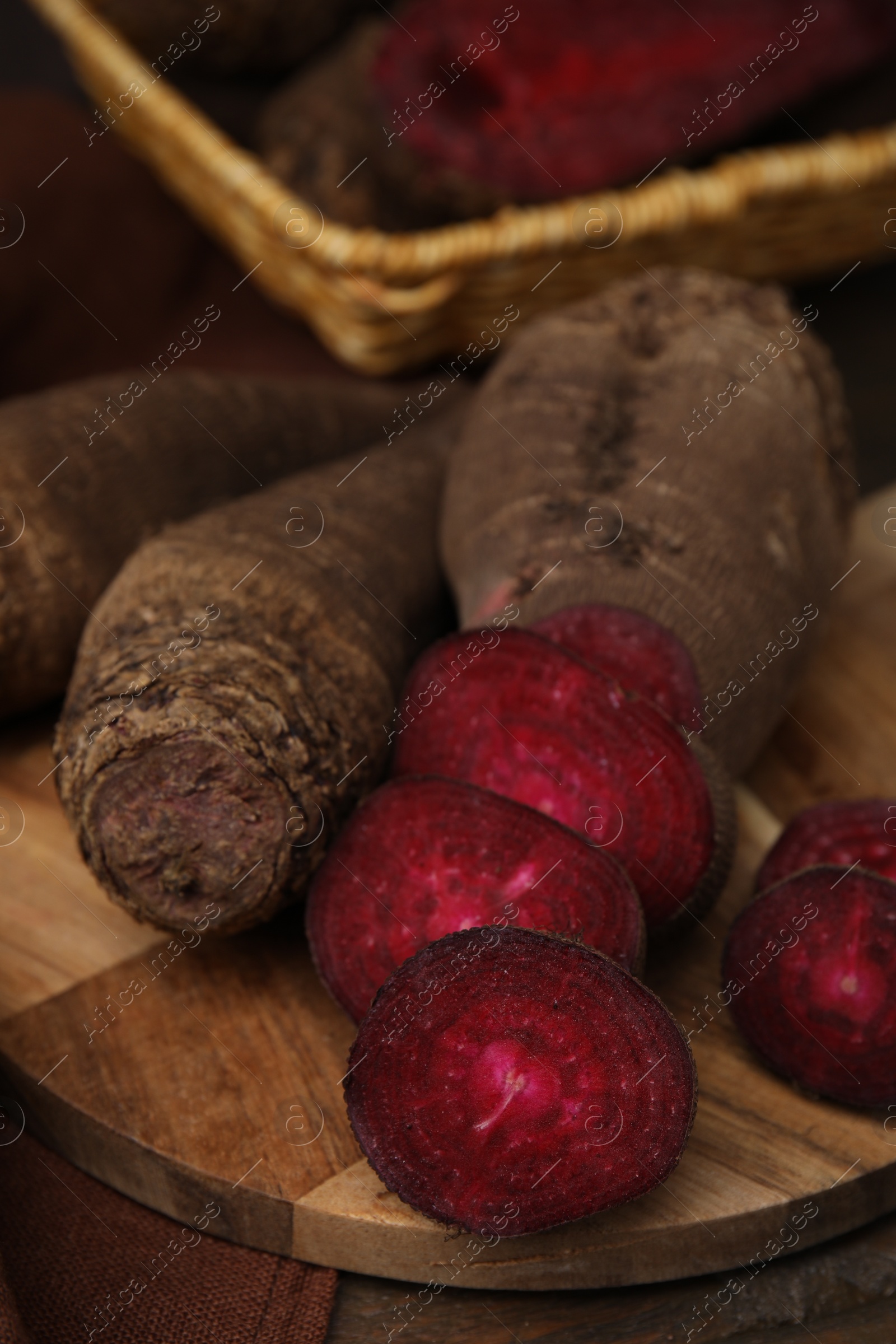 Photo of Whole and cut red beets on table, closeup