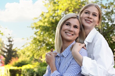 Photo of Happy mother with her daughter spending time together in park on sunny day