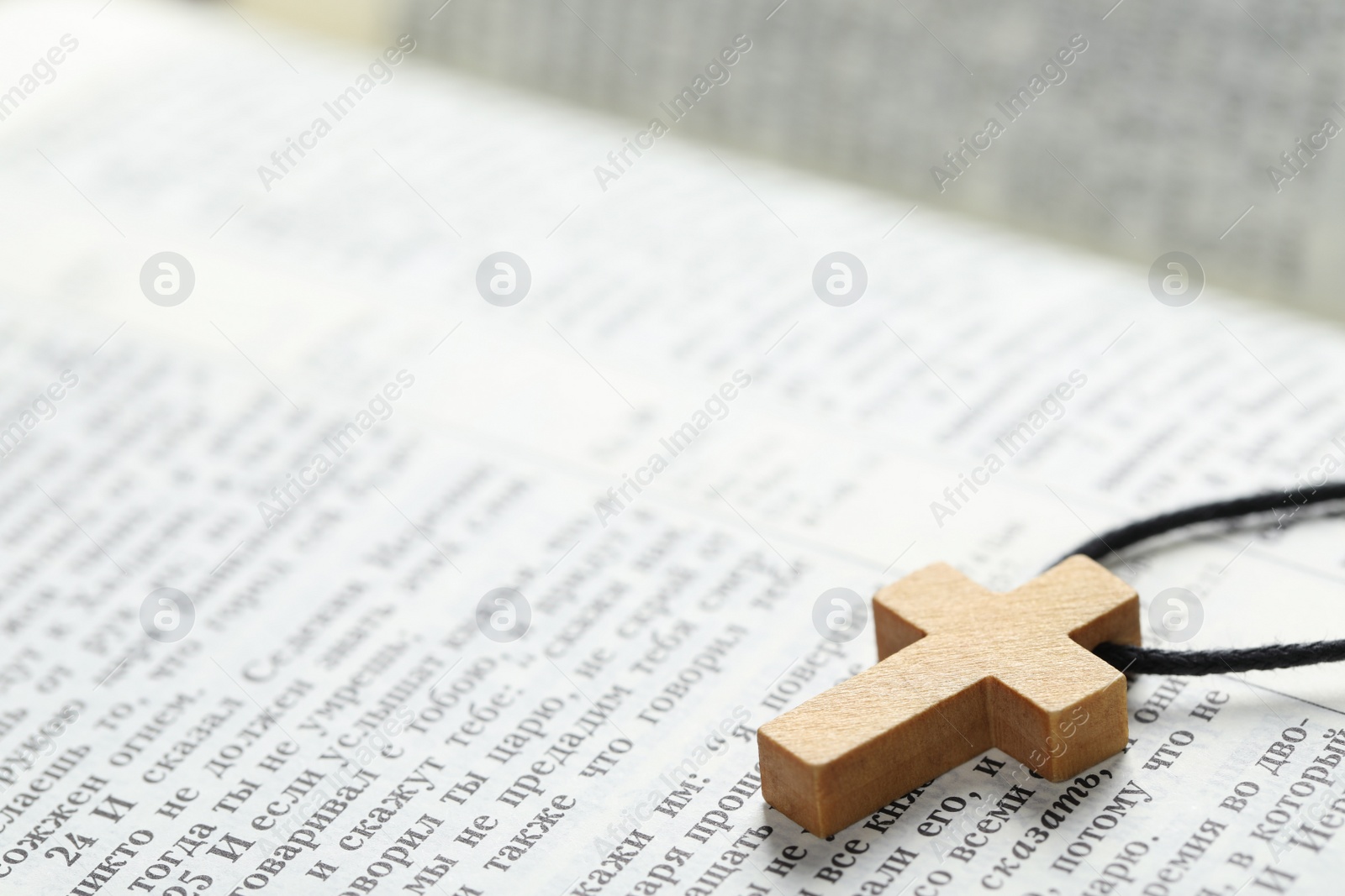 Photo of MYKOLAIV, UKRAINE - DECEMBER 21, 2021: Wooden cross on Bible, closeup. Text in russian