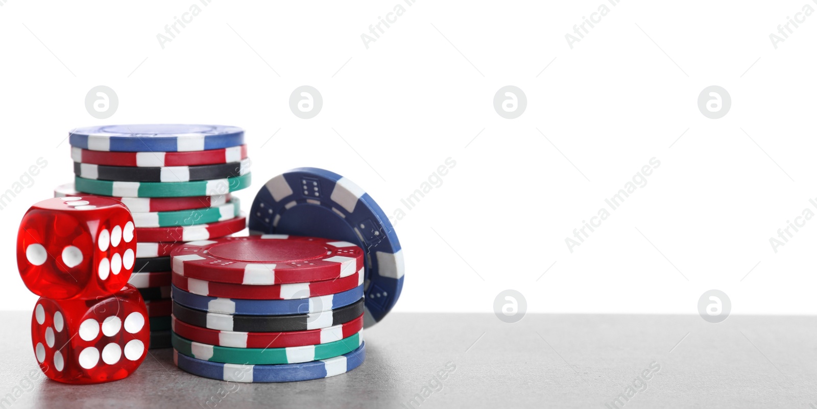 Photo of Gaming chips and dices on table against white background