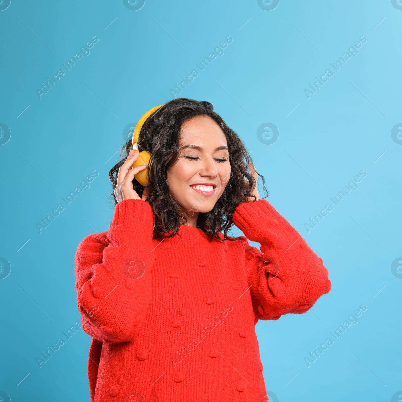 Photo of Happy young woman with headphones on blue background
