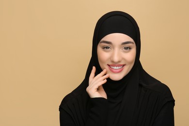 Portrait of Muslim woman in hijab on beige background