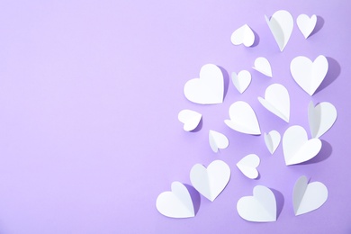 Photo of Small paper hearts on color background, top view