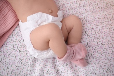 Little baby in diaper on bed, closeup