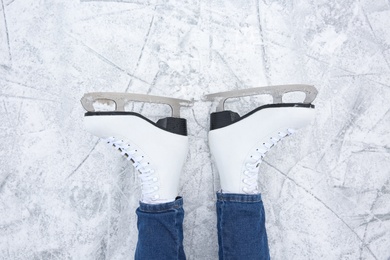 Photo of Woman wearing figure skates on ice rink, top view