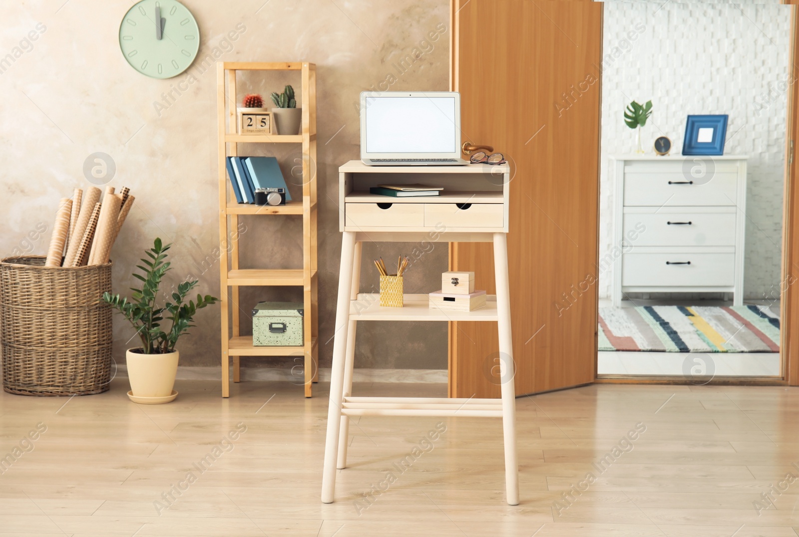 Photo of High wooden table with laptop as stand up workplace in modern interior