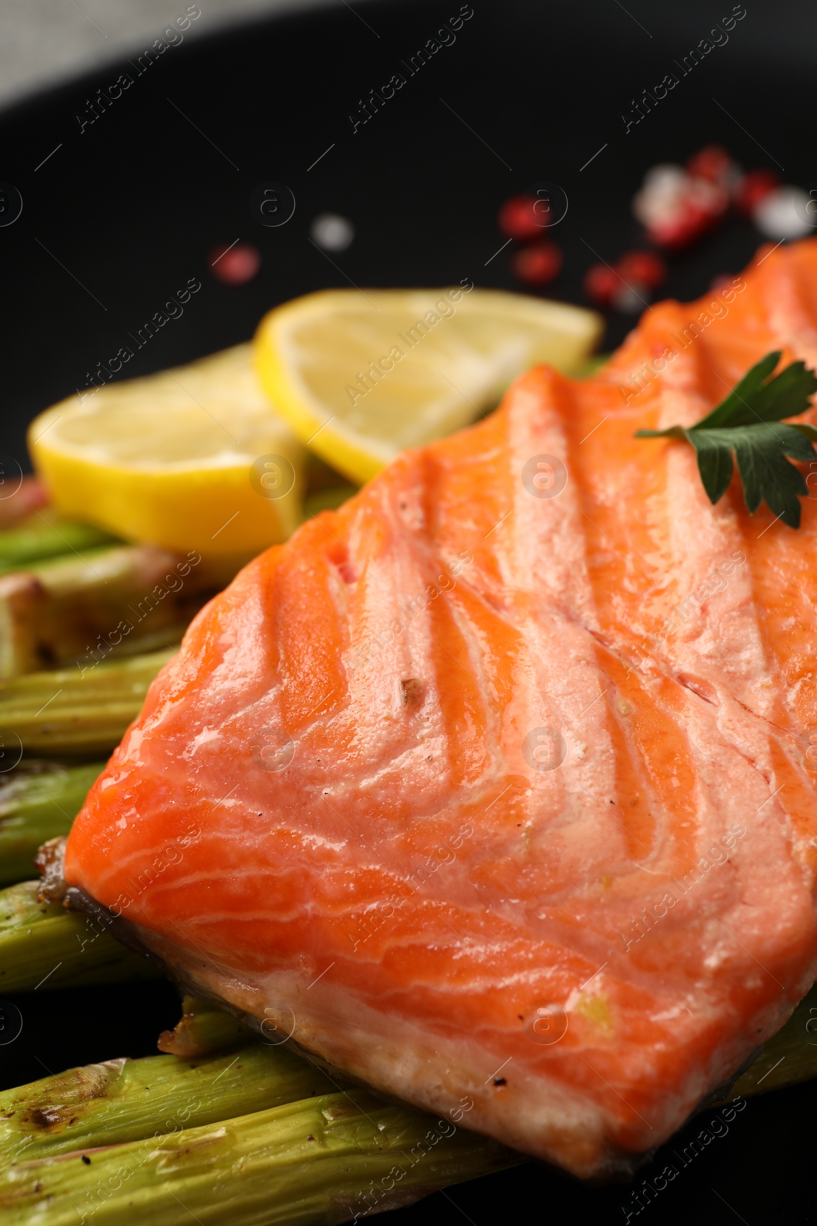 Photo of Tasty grilled salmon with asparagus on plate, closeup